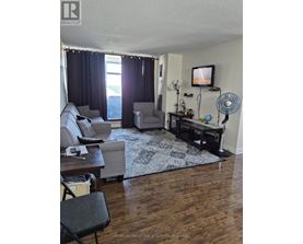 A living room with a television, a couch, a chair, and a table.