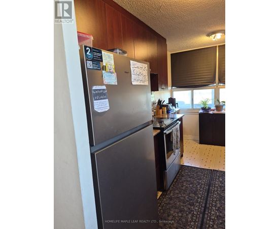 A fridge in a kitchen with a magnet on it.