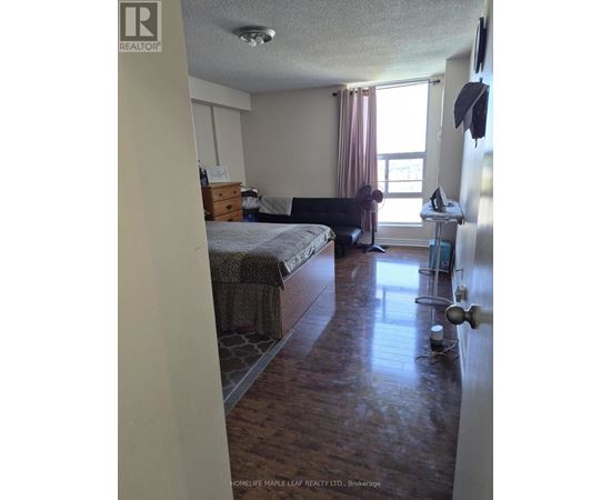 A bedroom with a bed, chair, and window.