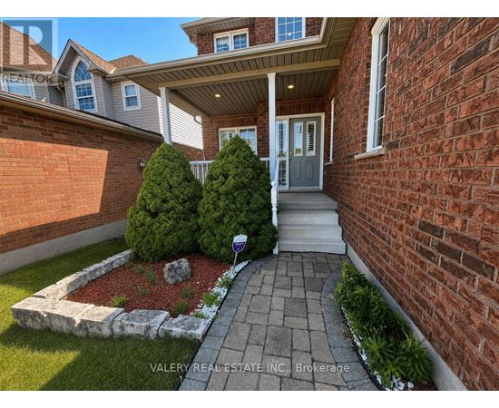 A house with a brick wall and a small garden in front.