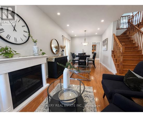 A living room with a fireplace and a large clock on the wall.