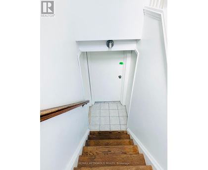 A stairway with a white door at the top.