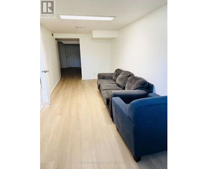 A living room with a grey couch and a blue ottoman.