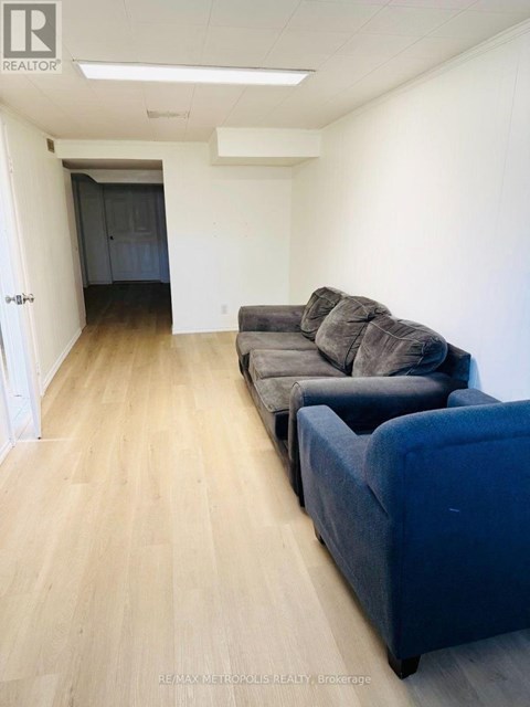 A living room with a grey couch and a blue ottoman.