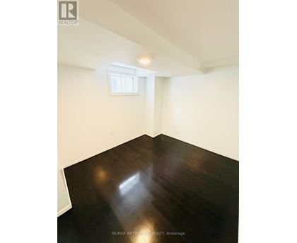 A room with a window and wooden flooring.