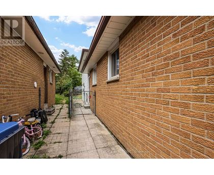 A brick wall with a bicycle and a blue container on the left.