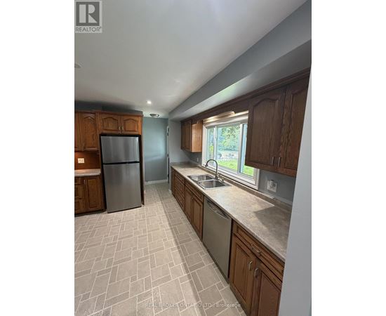 A kitchen with wooden cabinets and a tiled floor.