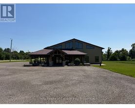A large building with a gravel parking lot in front of it.