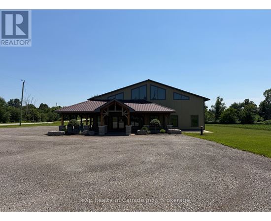 A large building with a gravel parking lot in front of it.