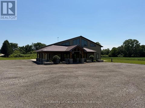 A large building with a brown roof and a parking lot in front.