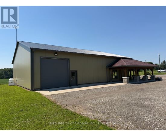 A large metal building with a garage door and a covered entrance.