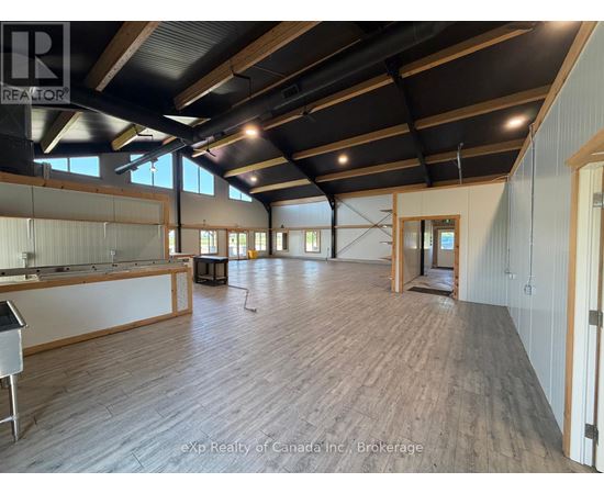 A large open space with wooden floors and exposed ceiling beams.