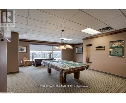 A room with a pool table and a chair.