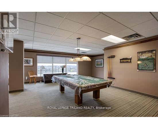 A room with a pool table and a chair.