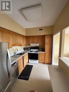 A kitchen with wooden cabinets and stainless steel appliances.