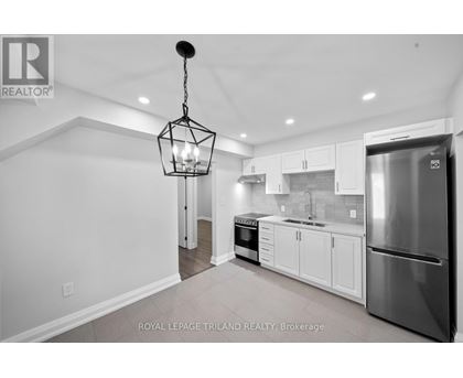 A modern kitchen with white cabinets and stainless steel appliances.