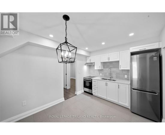 A modern kitchen with white cabinets and stainless steel appliances.