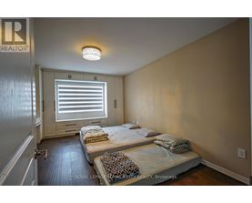 A bedroom with a bed and a window with blinds.
