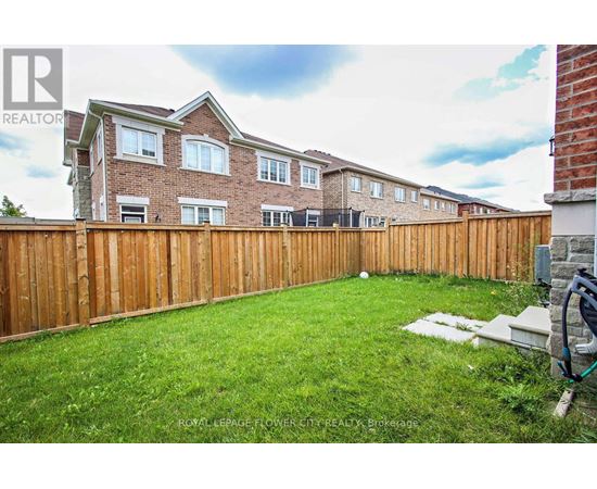A house with a brown fence and green grass in front.