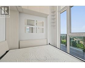 A bedroom with a large bed and a view of the city.
