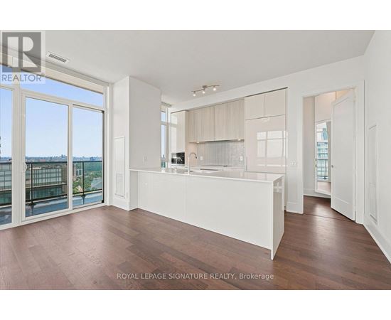 A spacious kitchen with white cabinets and a large island.