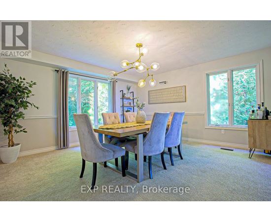 A dining room with a table set for four and a chandelier hanging from the ceiling.