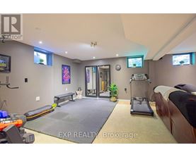 A gym room with a treadmill, exercise bench, and mirrors.