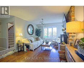 A well-lit living room with a couch, a coffee table, and a staircase.