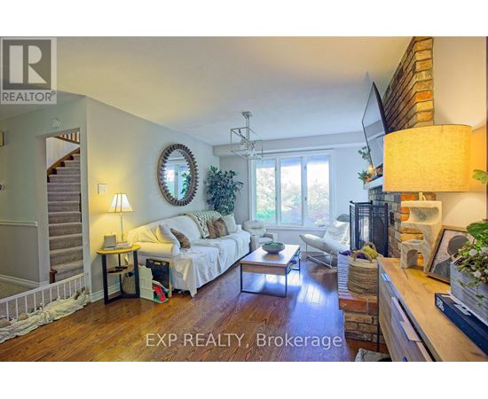 A well-lit living room with a couch, a coffee table, and a staircase.