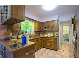 A kitchen with wooden cabinets and a tiled floor.