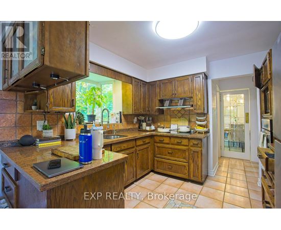 A kitchen with wooden cabinets and a tiled floor.