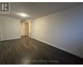 A room with wooden flooring and white walls, part of a property managed by Valery Real Estate Inc.