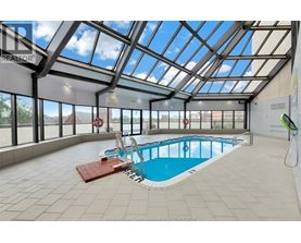 A large indoor swimming pool with a glass ceiling.