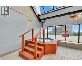 A hot tub is in a room with a skylight.