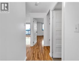 A hallway with wooden floors and white walls.