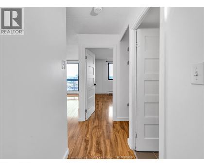A hallway with wooden floors and white walls.