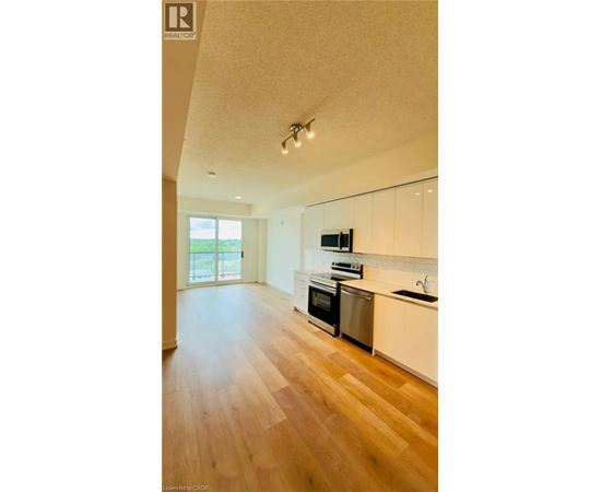 A kitchen with white cabinets and a wooden floor.