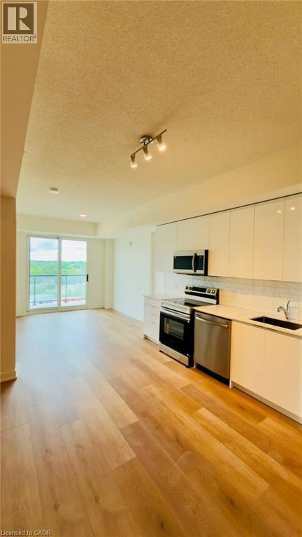 A kitchen with white cabinets and a wooden floor.