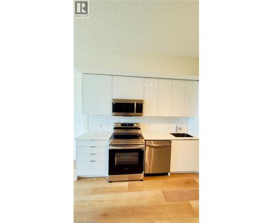 A modern kitchen with white cabinets and stainless steel appliances.