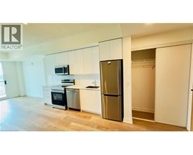 A kitchen with white cabinets and a stainless steel refrigerator.