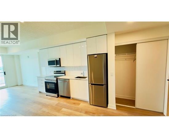 A kitchen with white cabinets and a stainless steel refrigerator.