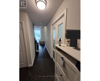 A hallway with a white door and a black floor.