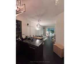 A kitchen with dark wood cabinets and a black floor.
