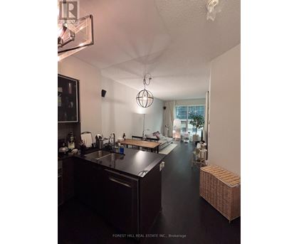 A kitchen with dark wood cabinets and a black floor.