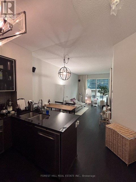 A kitchen with dark wood cabinets and a black floor.