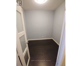 A small room with a door on the left and a window on the ceiling.