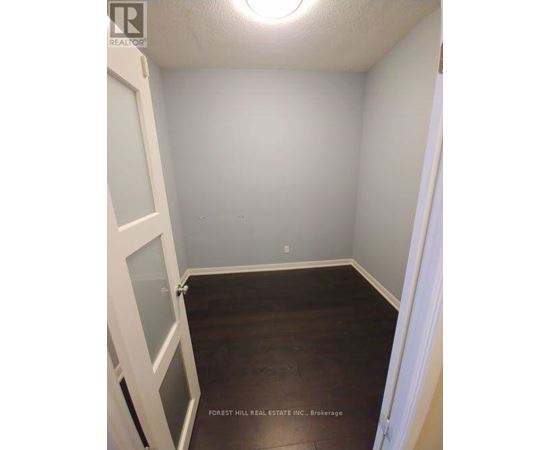 A small room with a door on the left and a window on the ceiling.