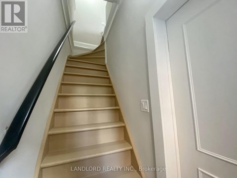 A staircase with a black railing and wooden steps.