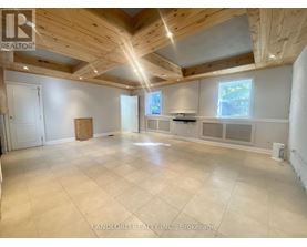 A spacious room with wooden ceiling and tiled floor.