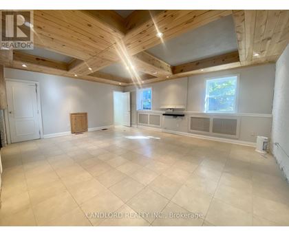 A spacious room with wooden ceiling and tiled floor.